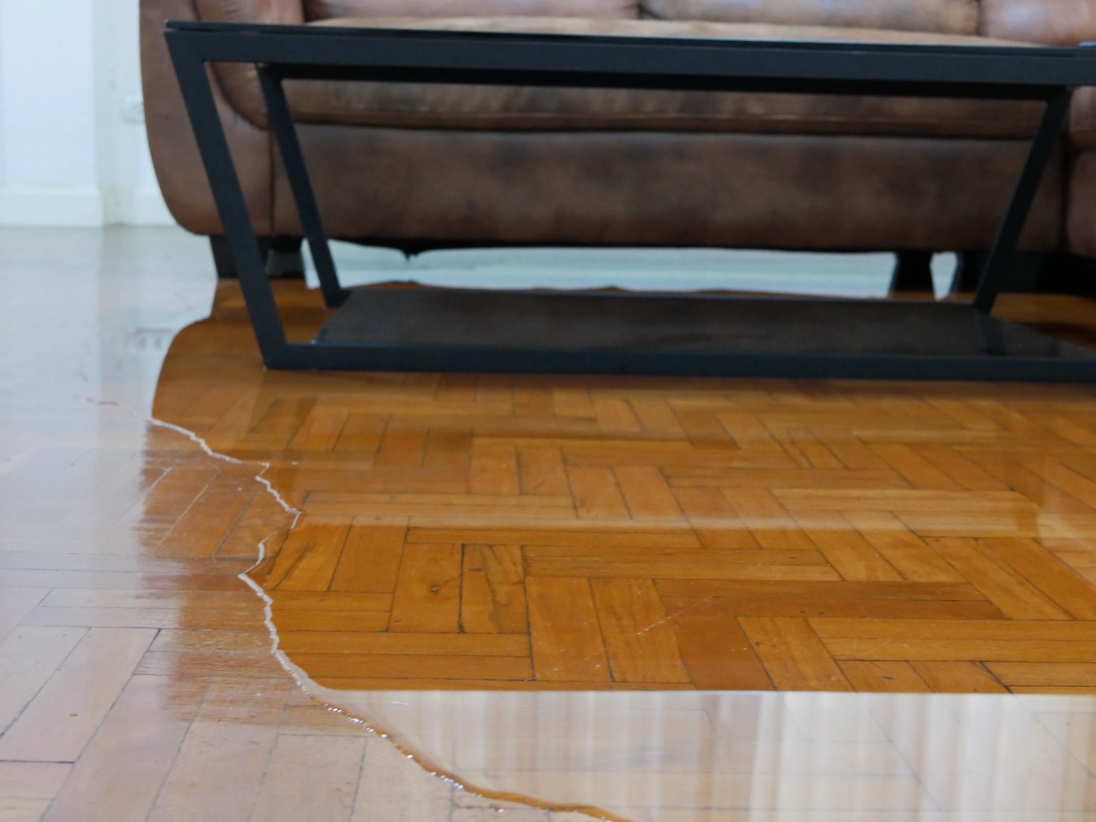 Buckled parquet floor with standing water in a living room
