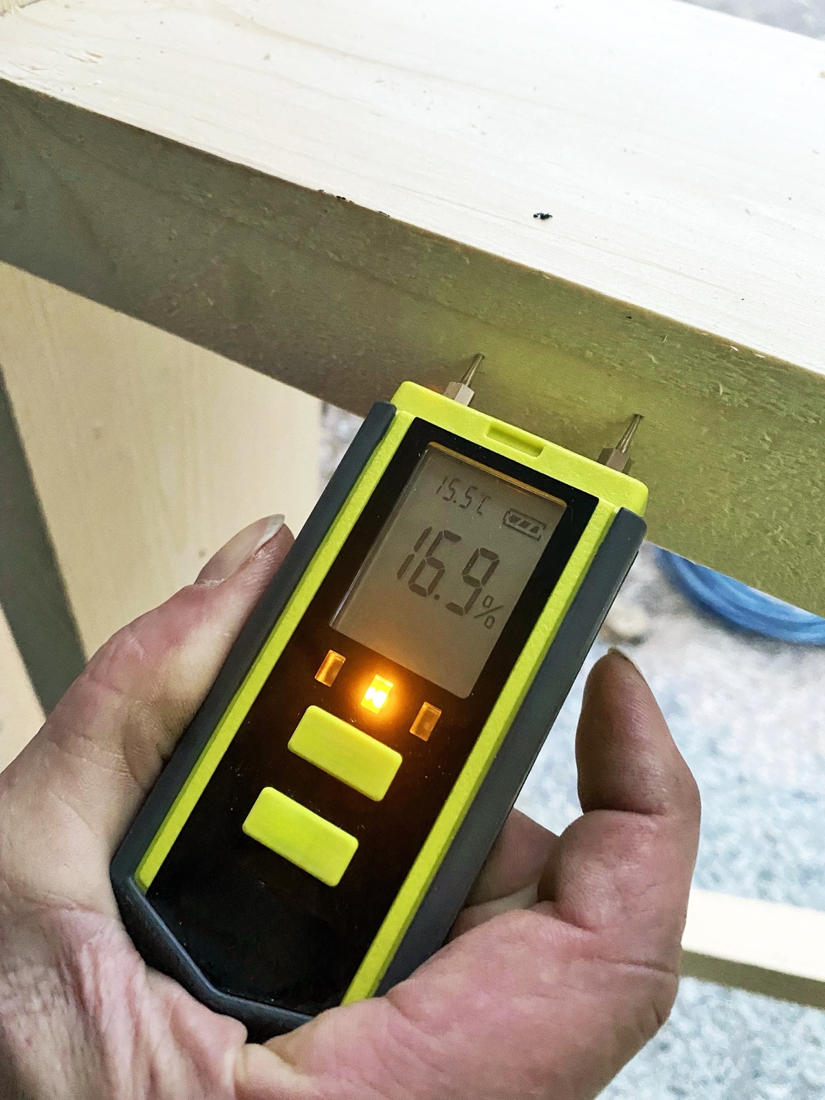 Digital moisture meter testing wood before installation