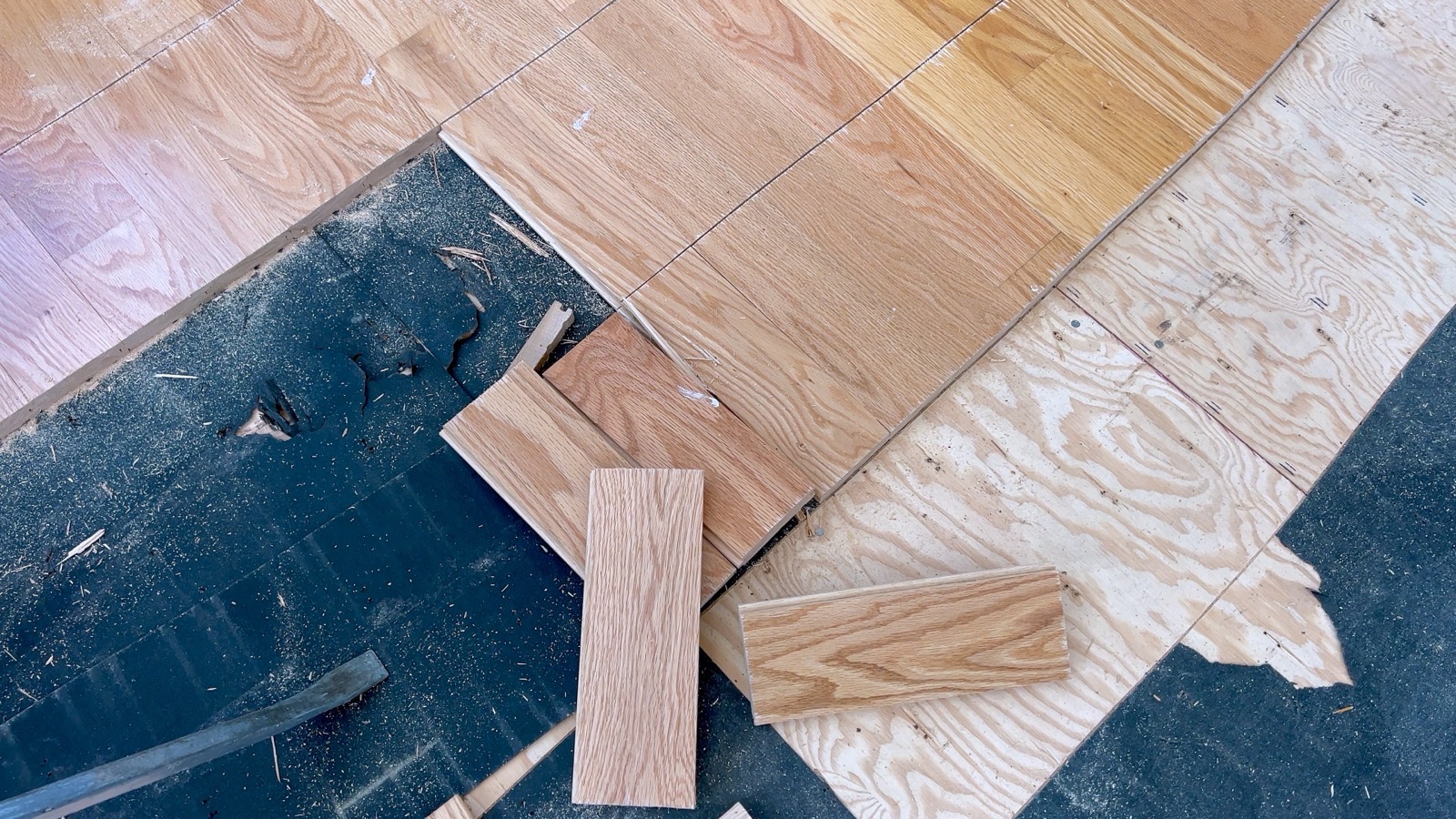 Oak flooring installed over a moisture barrier on a plywood subfloor