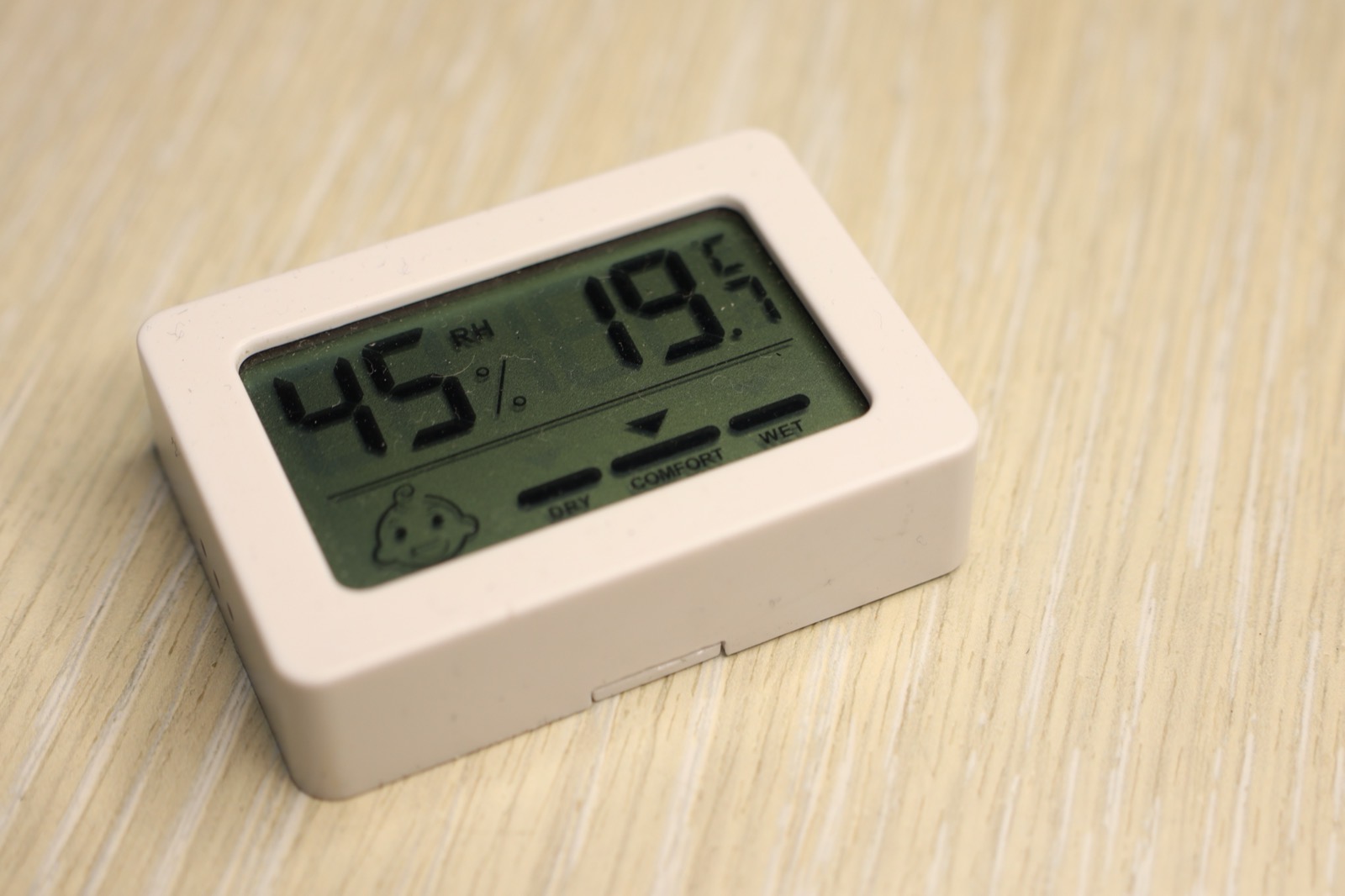 Digital hygrometer showing 45 percent relative humidity on a wood surface