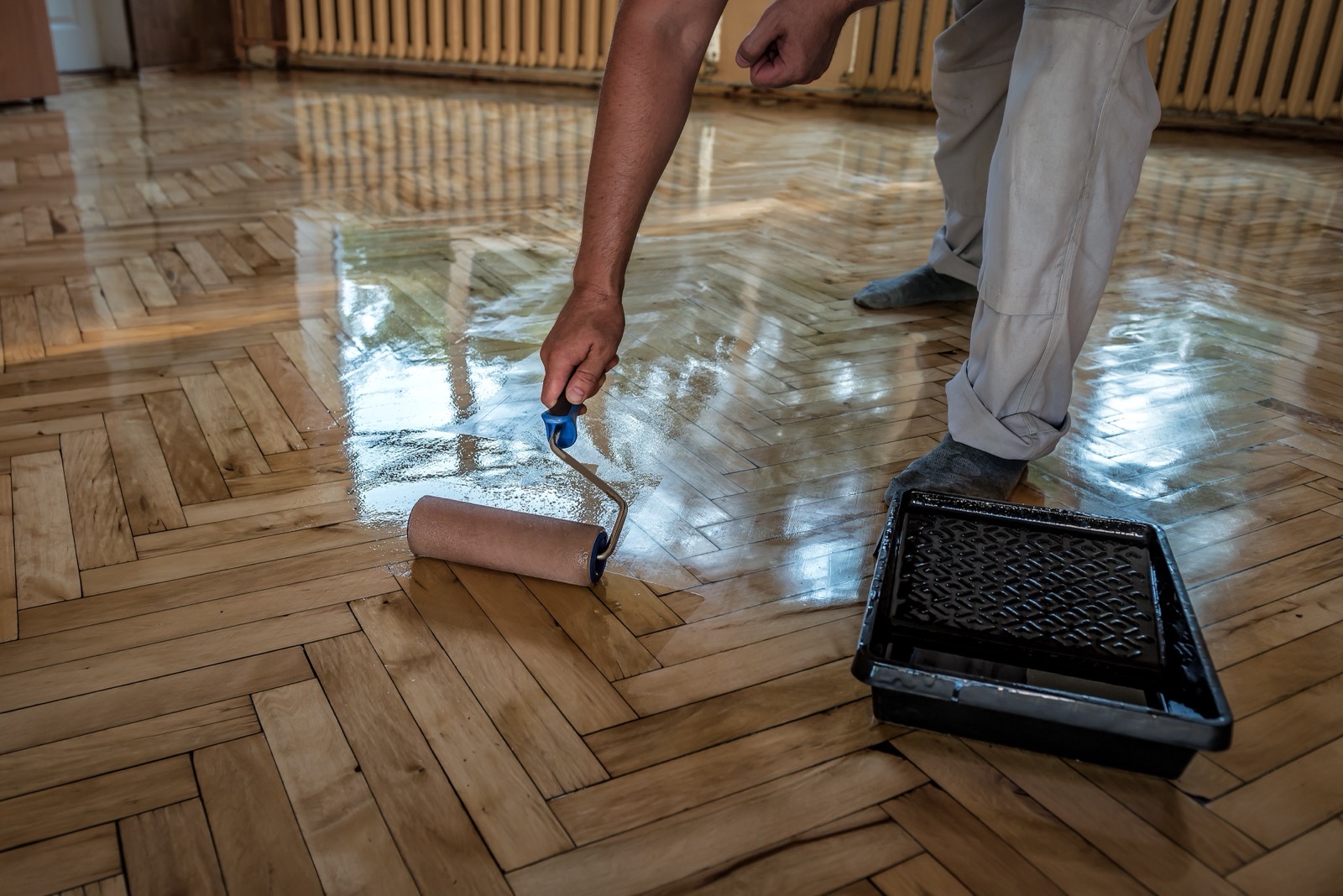 Applying finish to a parquet floor with a roller