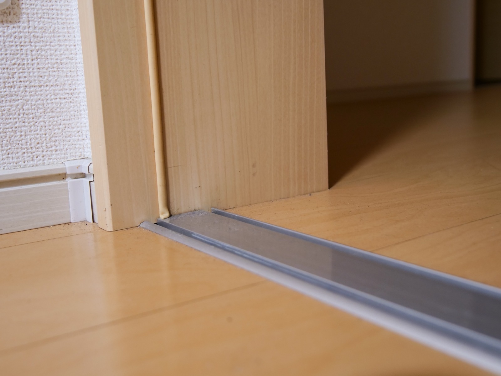 Metal transition strip in a doorway between wood floors