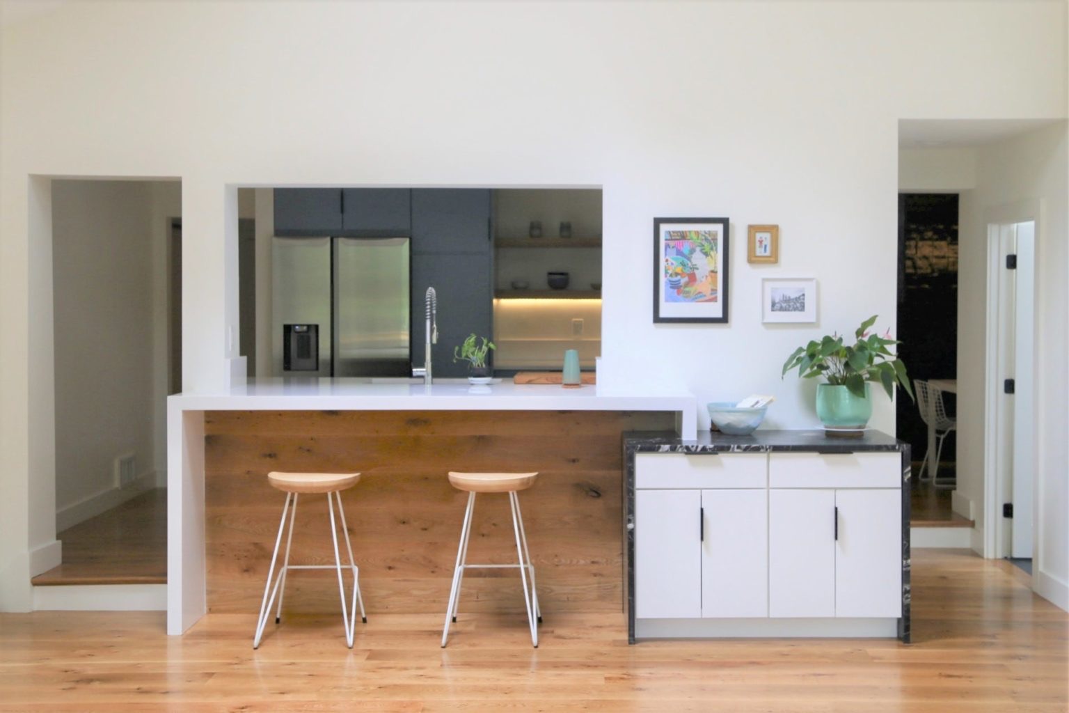 Open kitchen with white oak hardwood flooring and island seating