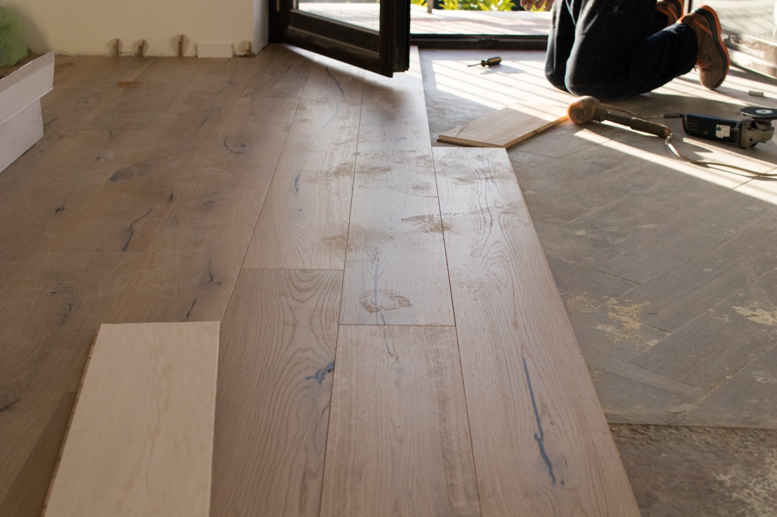Oak floorboards laid out mid-installation in a home