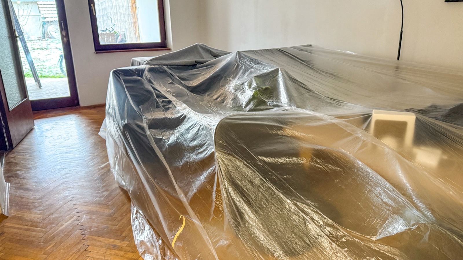 Furniture covered with plastic sheeting during a flooring project