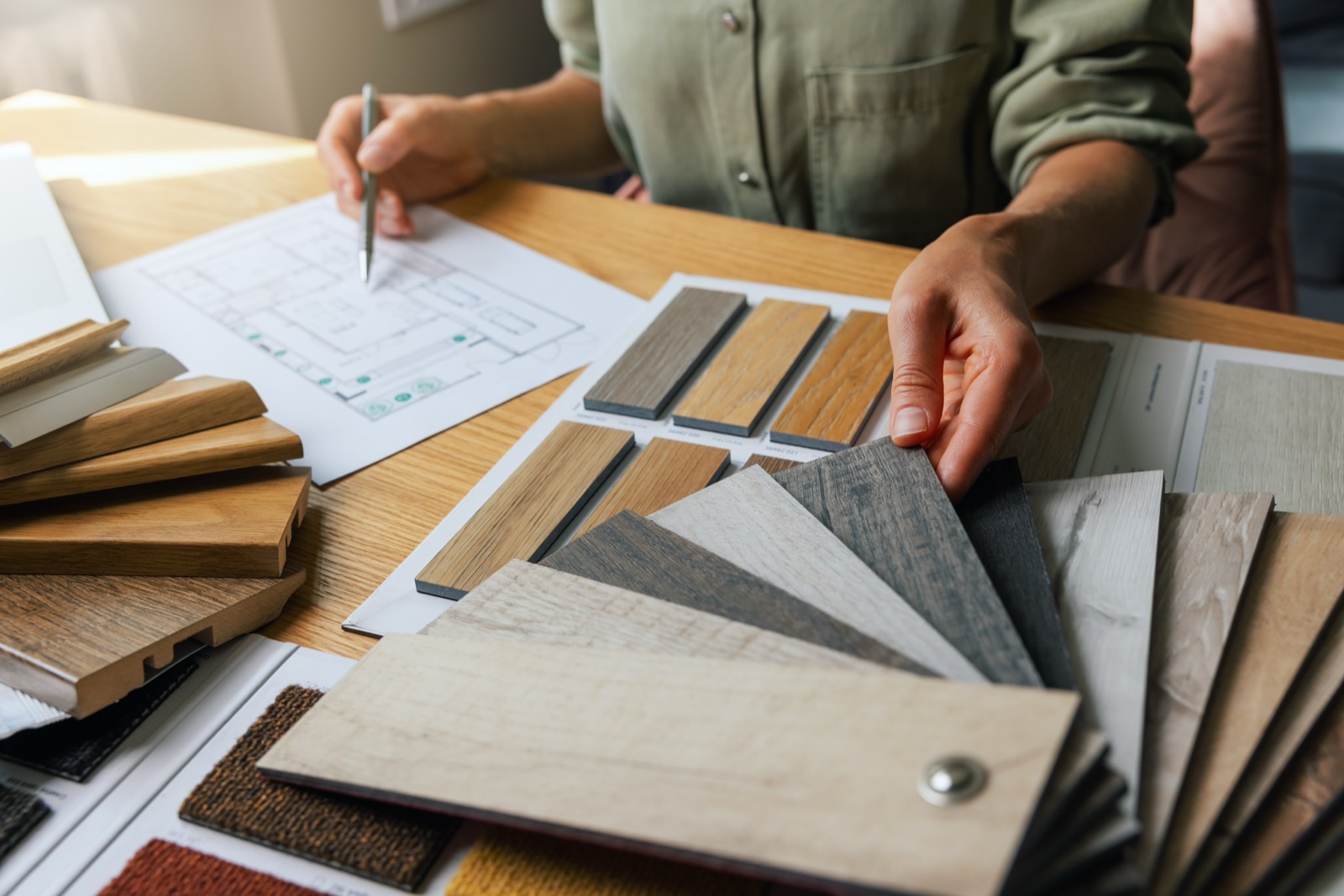Wood flooring samples and floor plans spread on a table